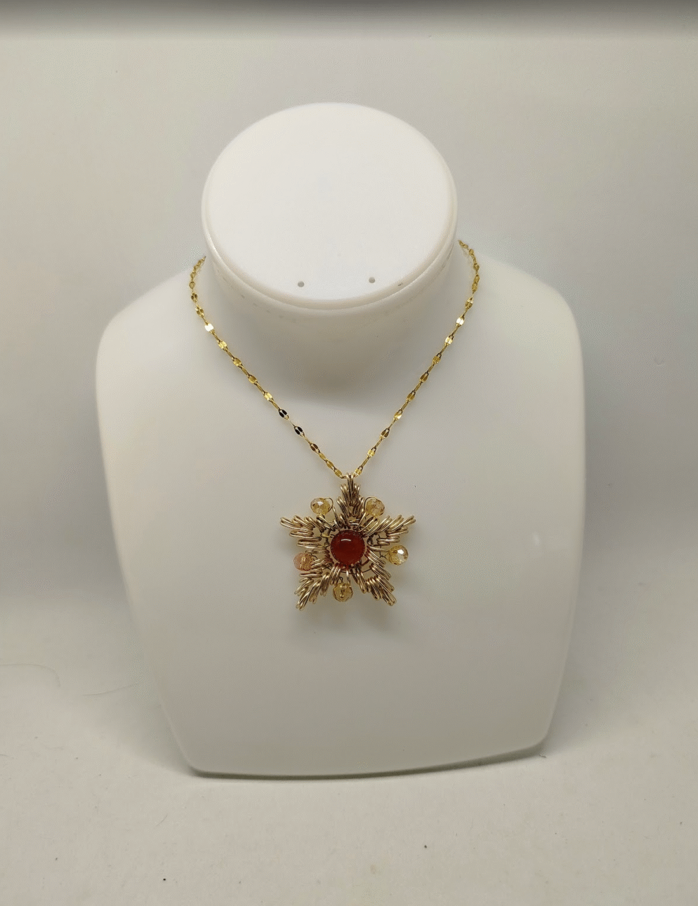 collier en forme de flocon avec fil aluminium doré et pierre calcédoine au centre