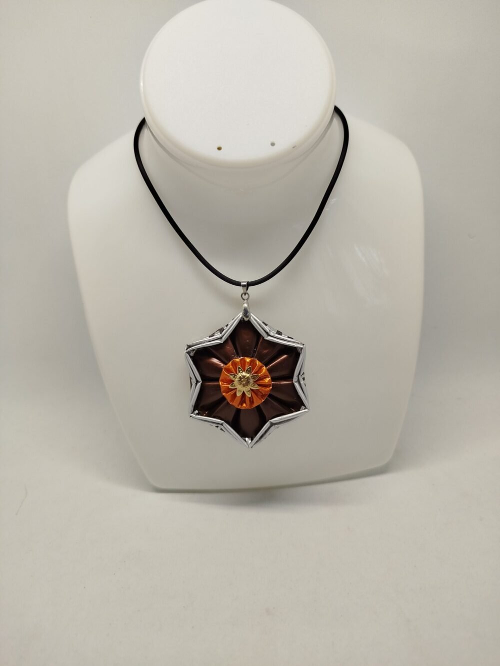 pendentif créé en capsules de café Nespresso VERTUO marron en forme d'étoile. Le collier est en caoutchouc noir avec fermoir mousqueton et petite ralonge.