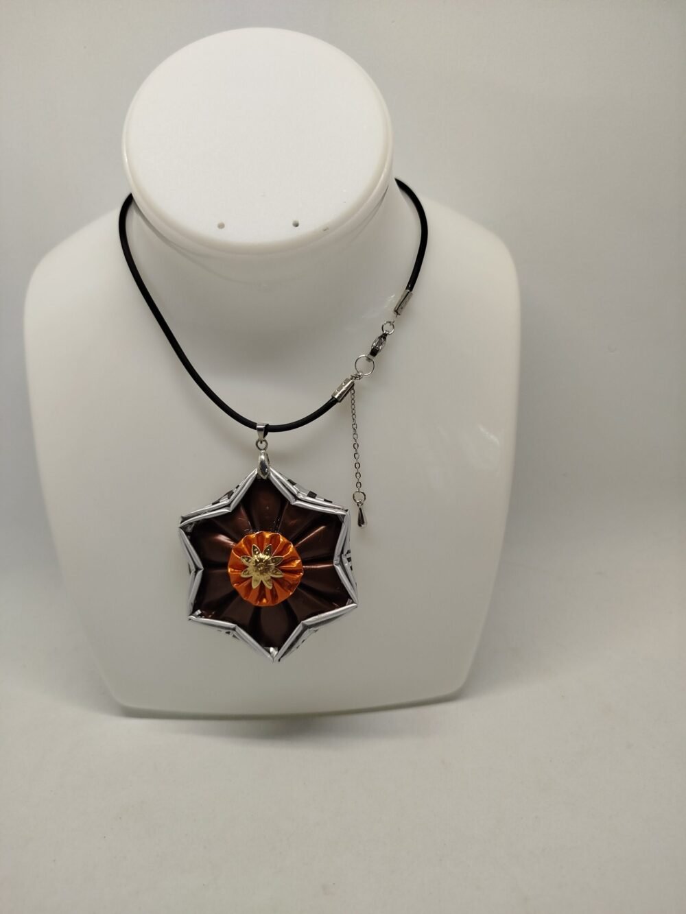 pendentif créé en capsules de café Nespresso VERTUO marron en forme d'étoile. Le collier est en caoutchouc noir avec fermoir mousqueton et petite ralonge.