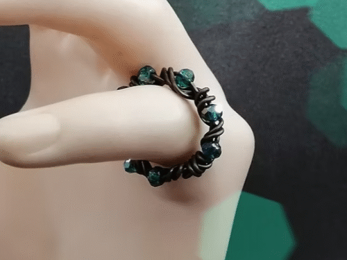 bague tressée en fil aluminium bronze et des perles à facettes vertes