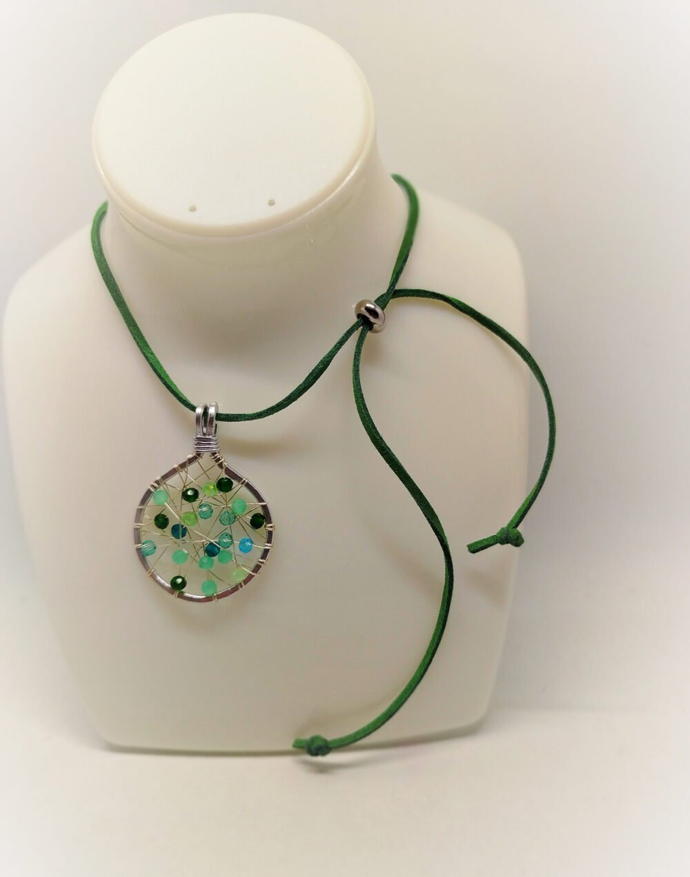collier-femme-pendentif-de-4-cm en-fil-aluminium-argente-avec-perles-en-verre-de-différentes-tons-verts-tissés-au-centre-