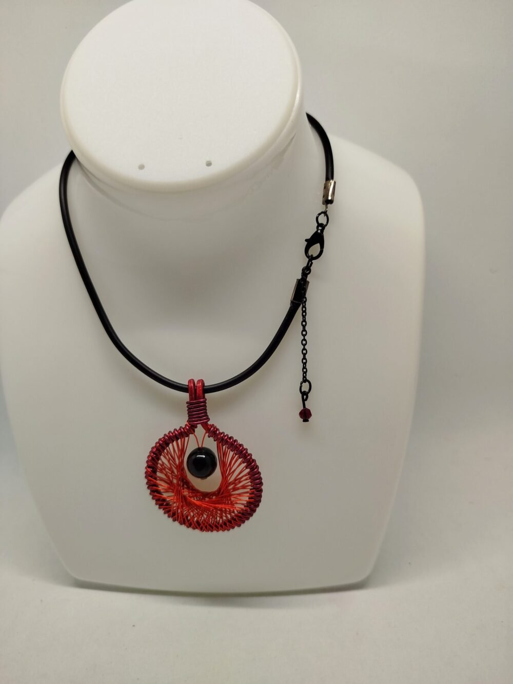 pendentif en fil aluminium rouge tissé à l'intérieur et pierre onyx à facettes fixé à l'intérieur