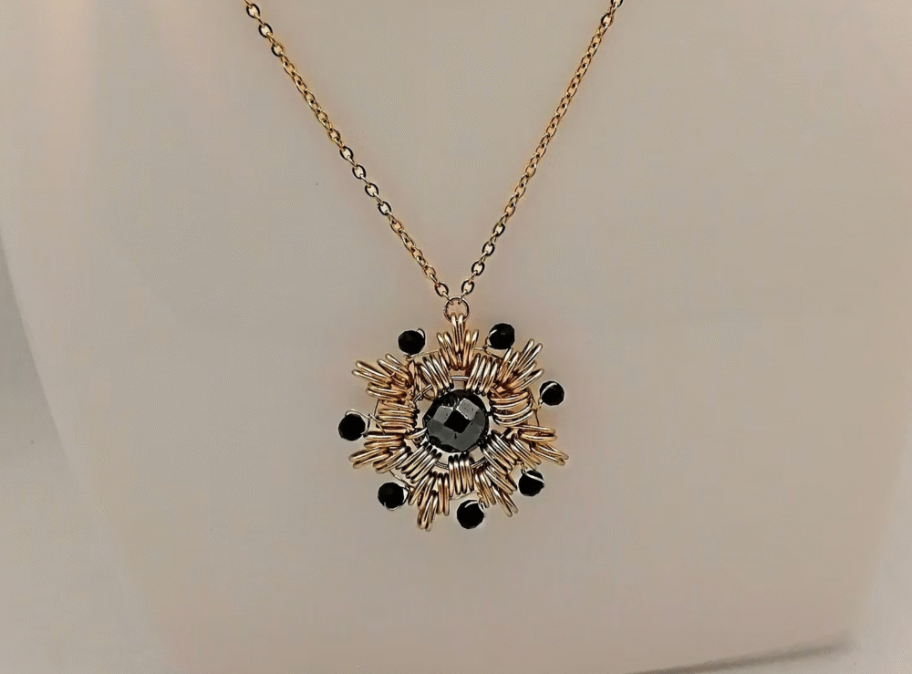 collier en forme de flocon avec fil aluminium doré et pierre hématite au centre