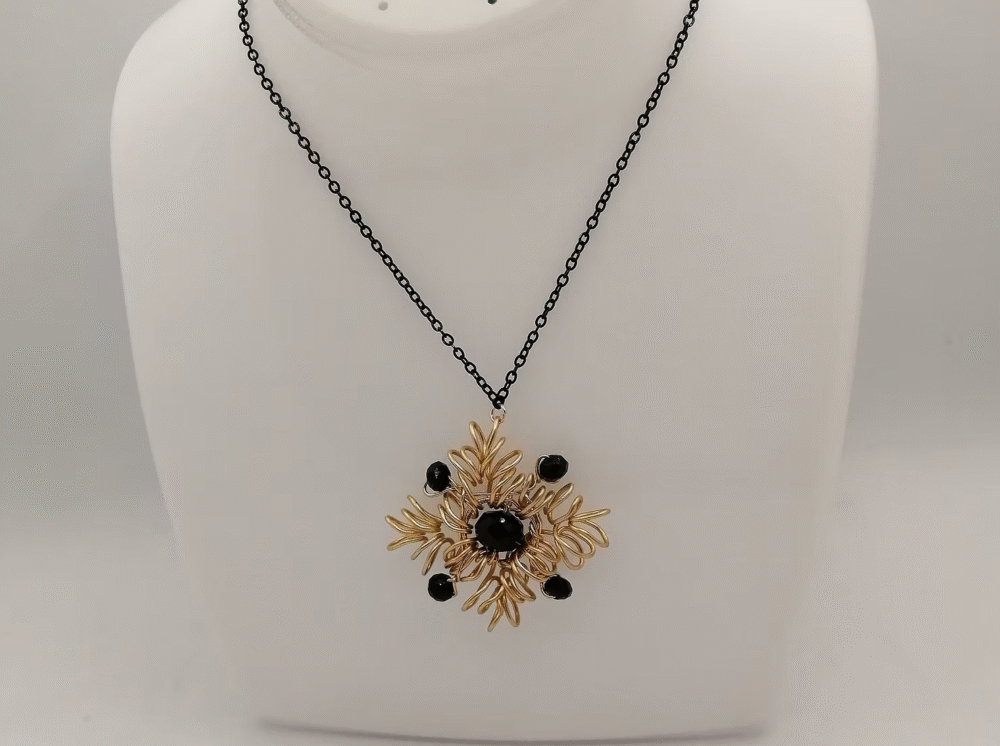 collier en forme de flocon avec fil aluminium doré et pierre onyx au centre