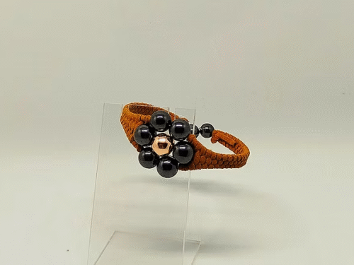 bracelet tressé avec du fil suédine et de magnifiques pierres naturelles hématites en forme de fleur sa taille est variable