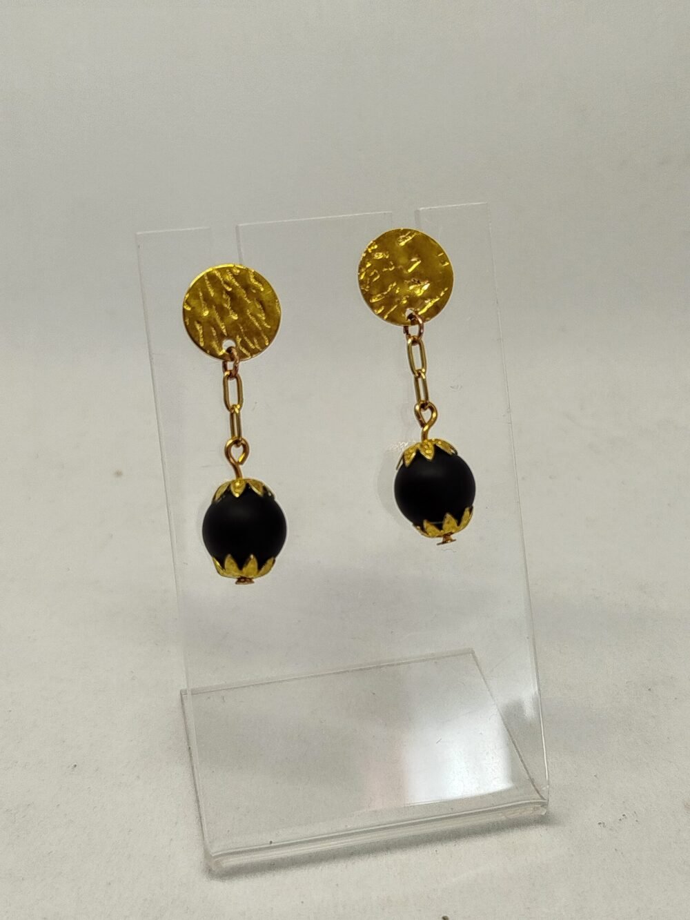 clous d'oreilles dorés et pierres onyx entourés de pétales de perles dorées