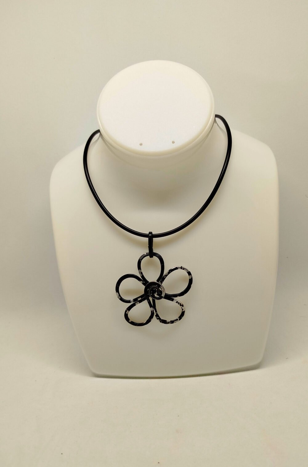 pendentif est soigneusement confectionné en forme de fleur en fil d'aluminium noir légèrement martelé
