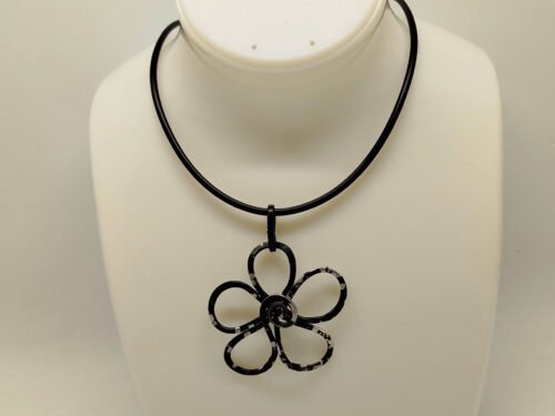 pendentif est soigneusement confectionné en forme de fleur en fil d'aluminium noir légèrement martelé
