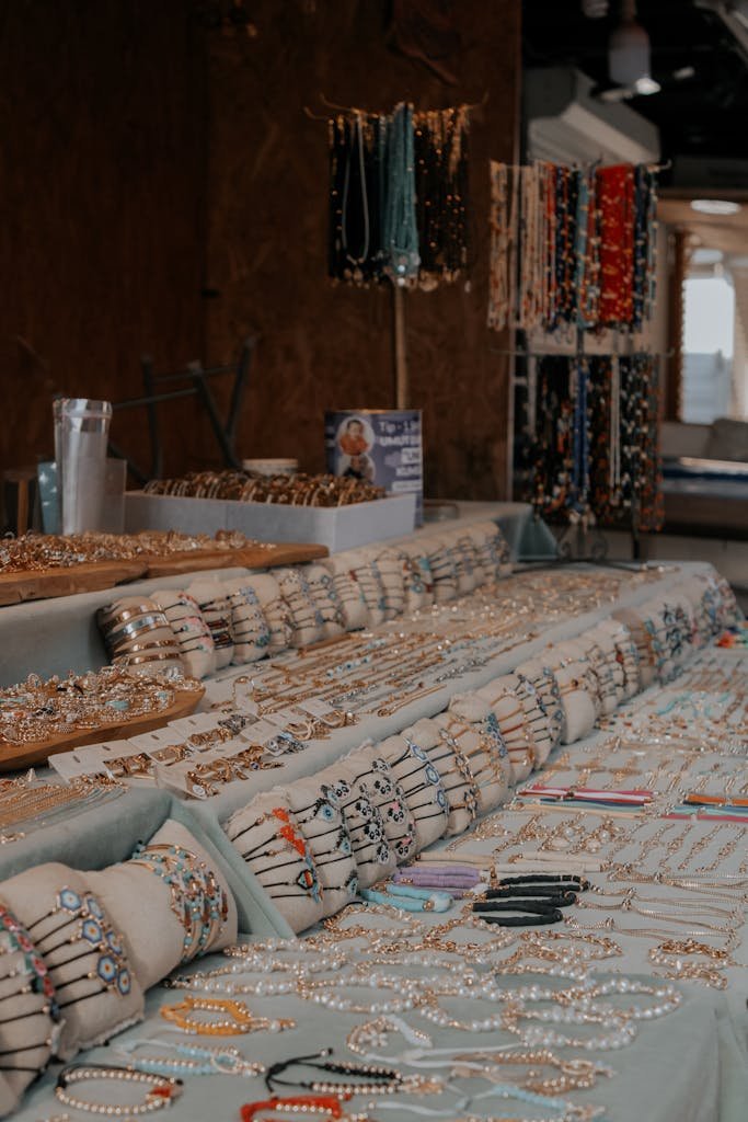 Un éventail de bracelets, de colliers et de bijoux fabriqués à la main exposés sur des tables dans un cadre de marché.