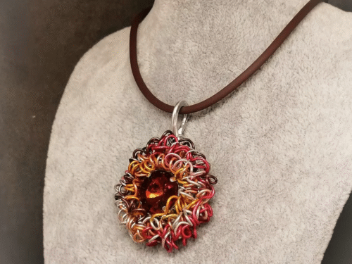 Collier Glamour à Strass avec gros pendentif en fil aluminium et strass rouge au centre Collier Glamour à Strass avec gros pendentif en fil aluminium et strass rouge au centre