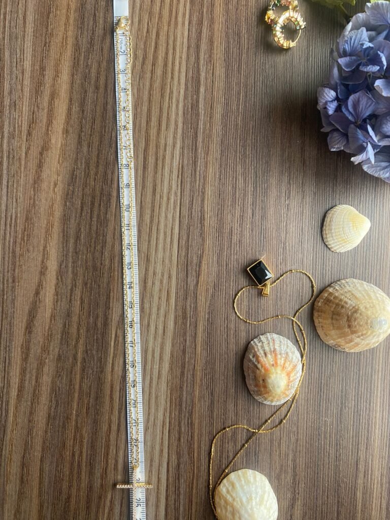 prise de mesure d'un collier avec un mètre et des coquillages