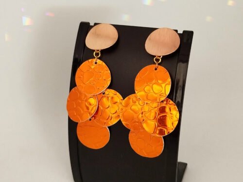 boucles d'oreilles créées en fil aluminium plat strié couleur safrane motif crocodile, accrochées à un gros clou d'oreilles dorées