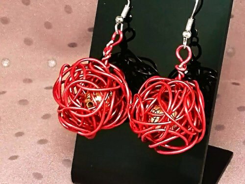 boucles d'oreilles en forme de boule soigneusement confectionnées en forme de boule en fil aluminium rouge avec perle à l'intérieur