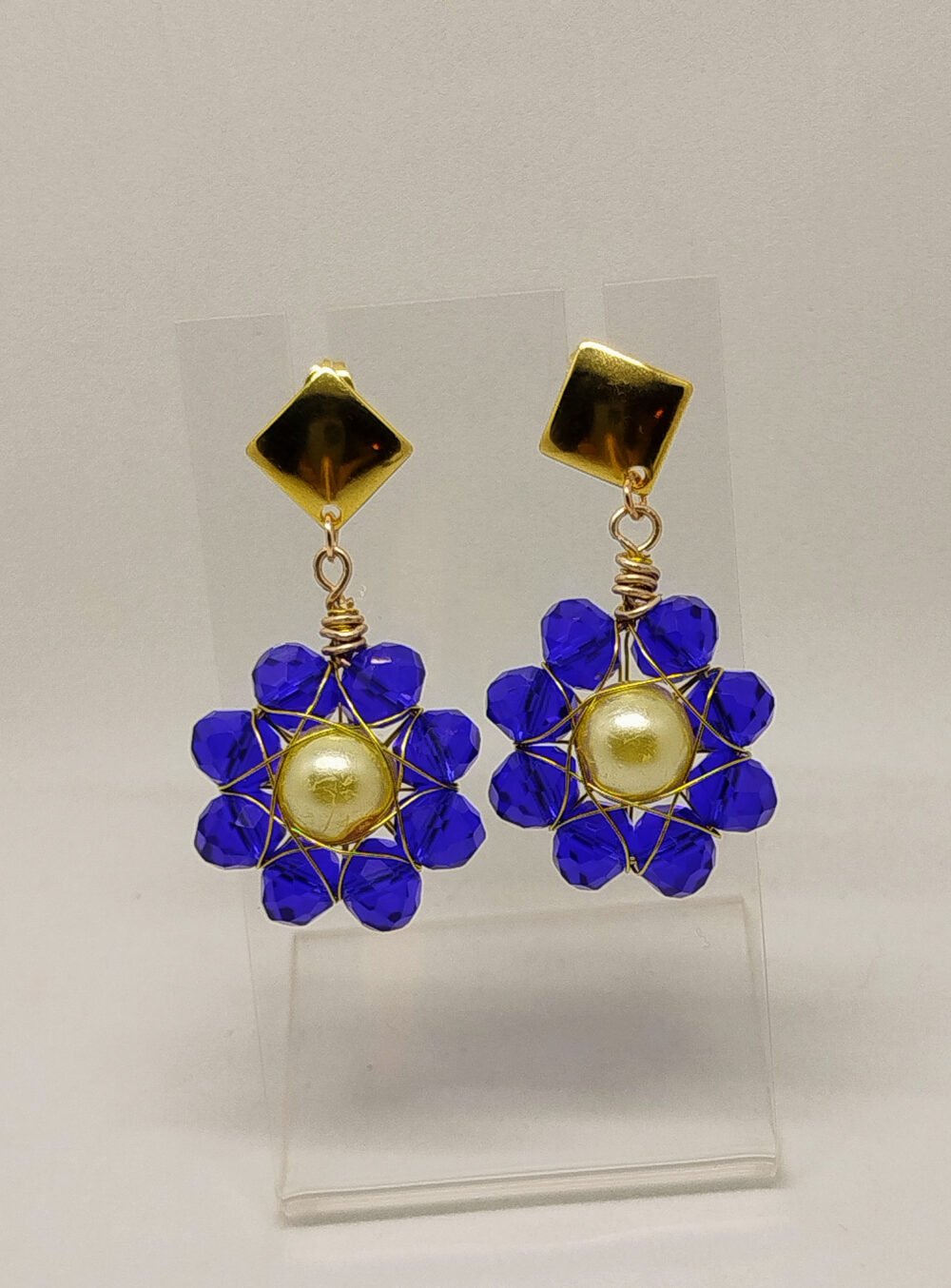 boucles d'oreilles en forme de fleur avec perles à facettes bleu intense entourées de fil aluminium doré et crochets en acier hypoallergéniques
