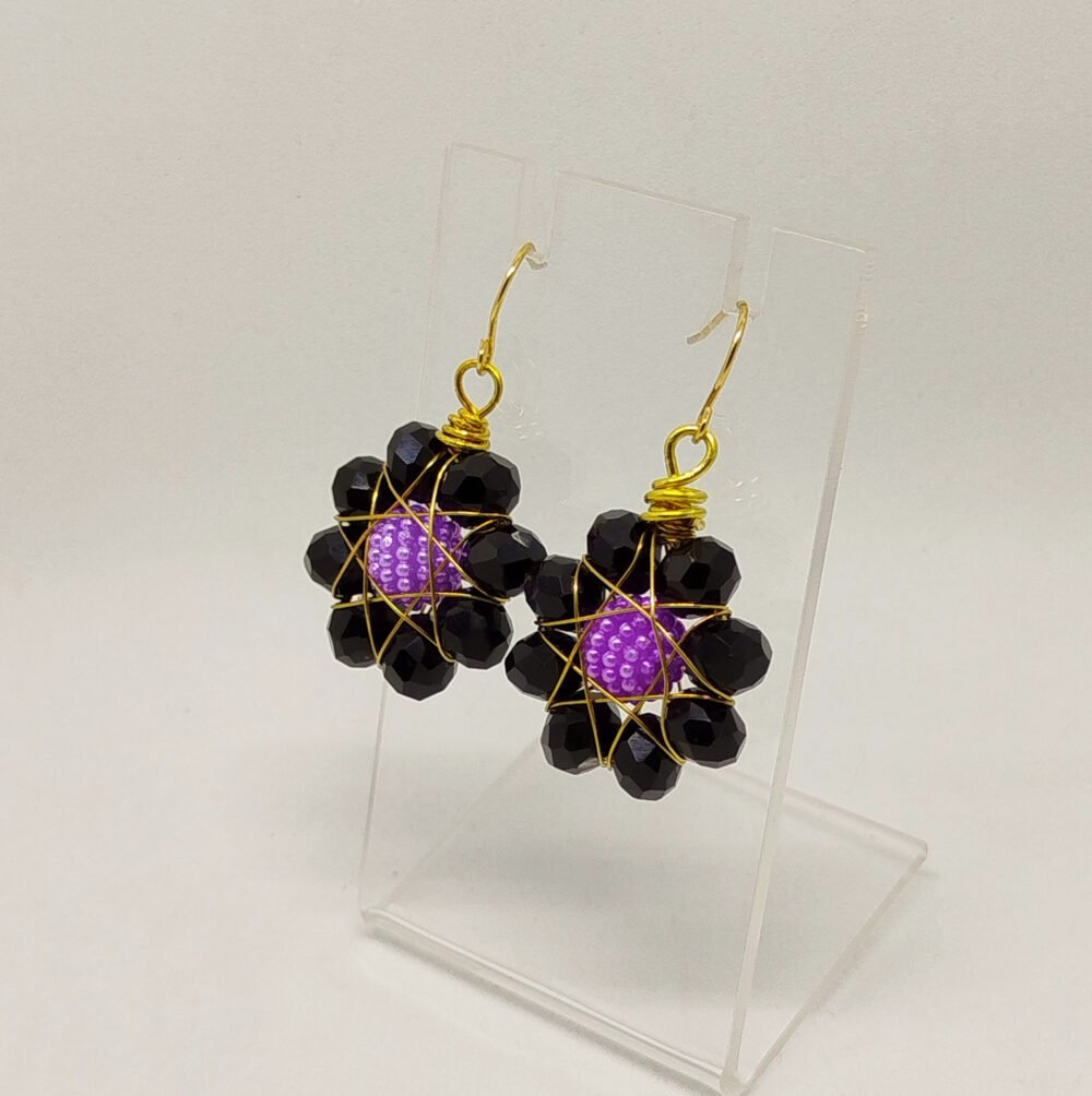 boucles d'oreilles en forme de fleur avec perles à facettes noir entourées de fil aluminium doré et crochets en acier doré