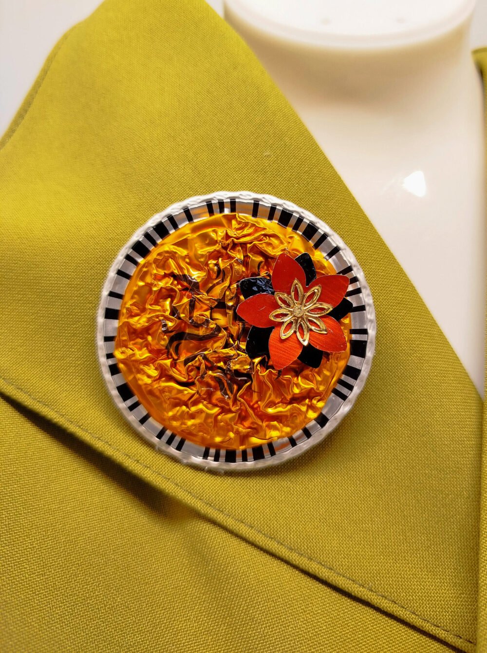 broche créé en capsules de café orange avec petite fleur fixé dessus diamètre 6 cm éco créative