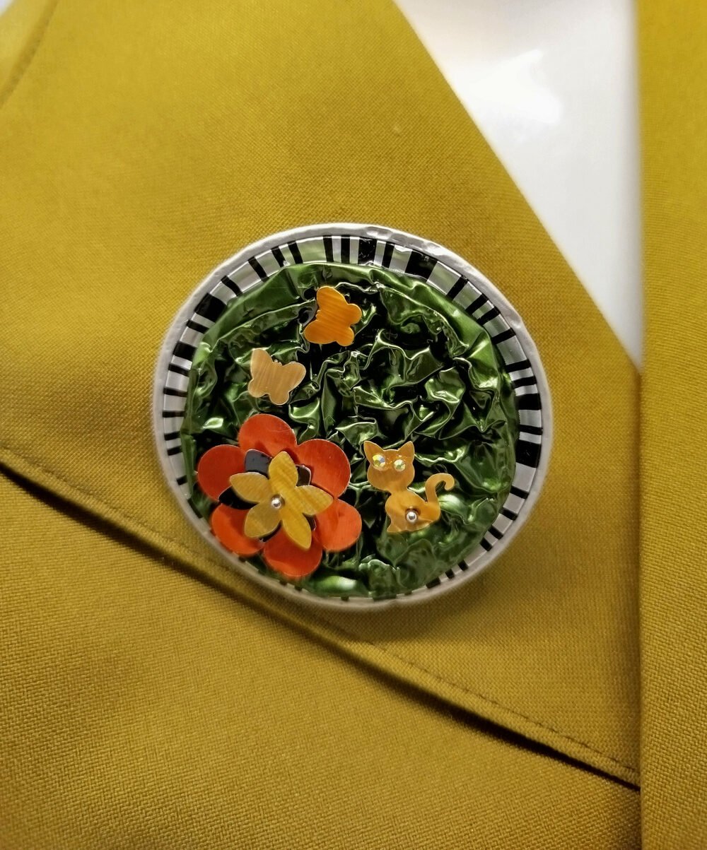 broche créé en capsules de café verte avec petite fleur et petit chat fixé dessus diamètre 6 cm