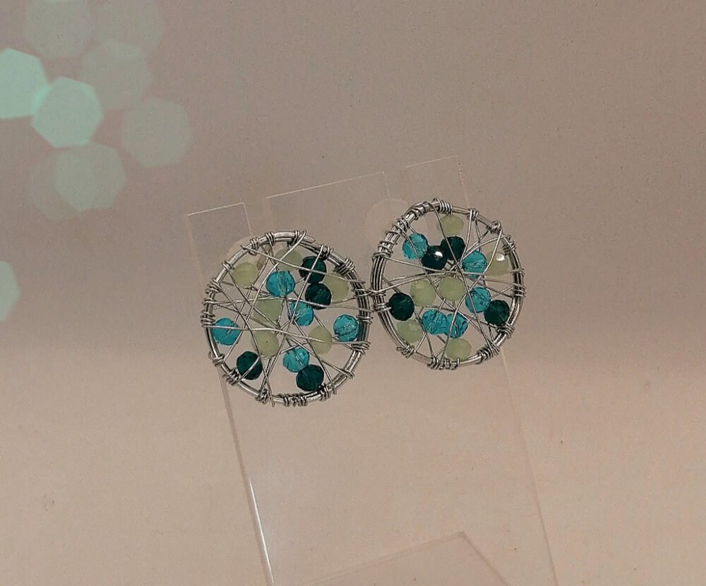 clous d'oreilles confectionnées avec du fil de cuivre couleur argenté remplit de perles à facettes vertes bijou fait main