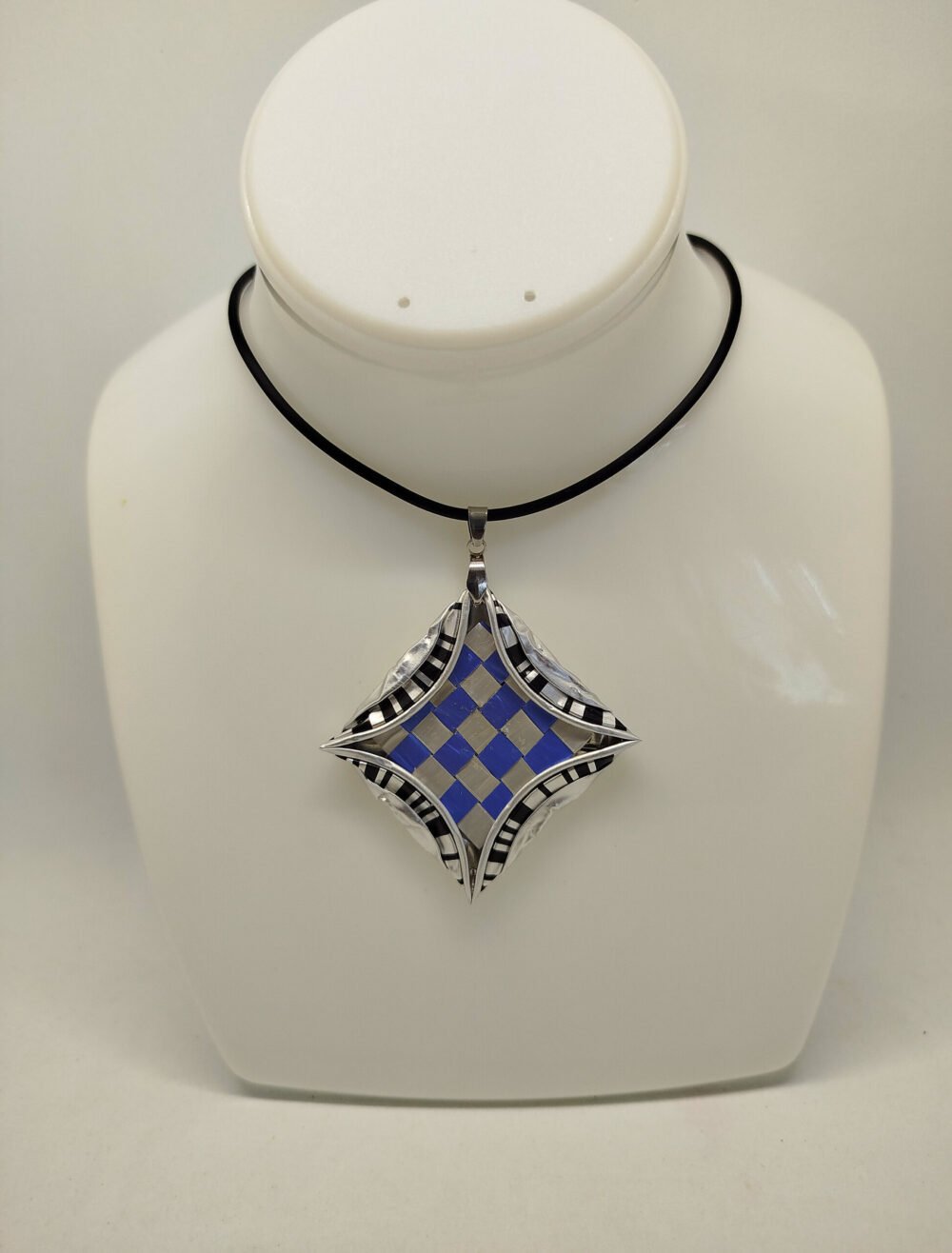 collier en caoutchouc noir avec fermoir mousqueton et pendentif créé en capsules de café et dessin géométrique carré bleu au centre