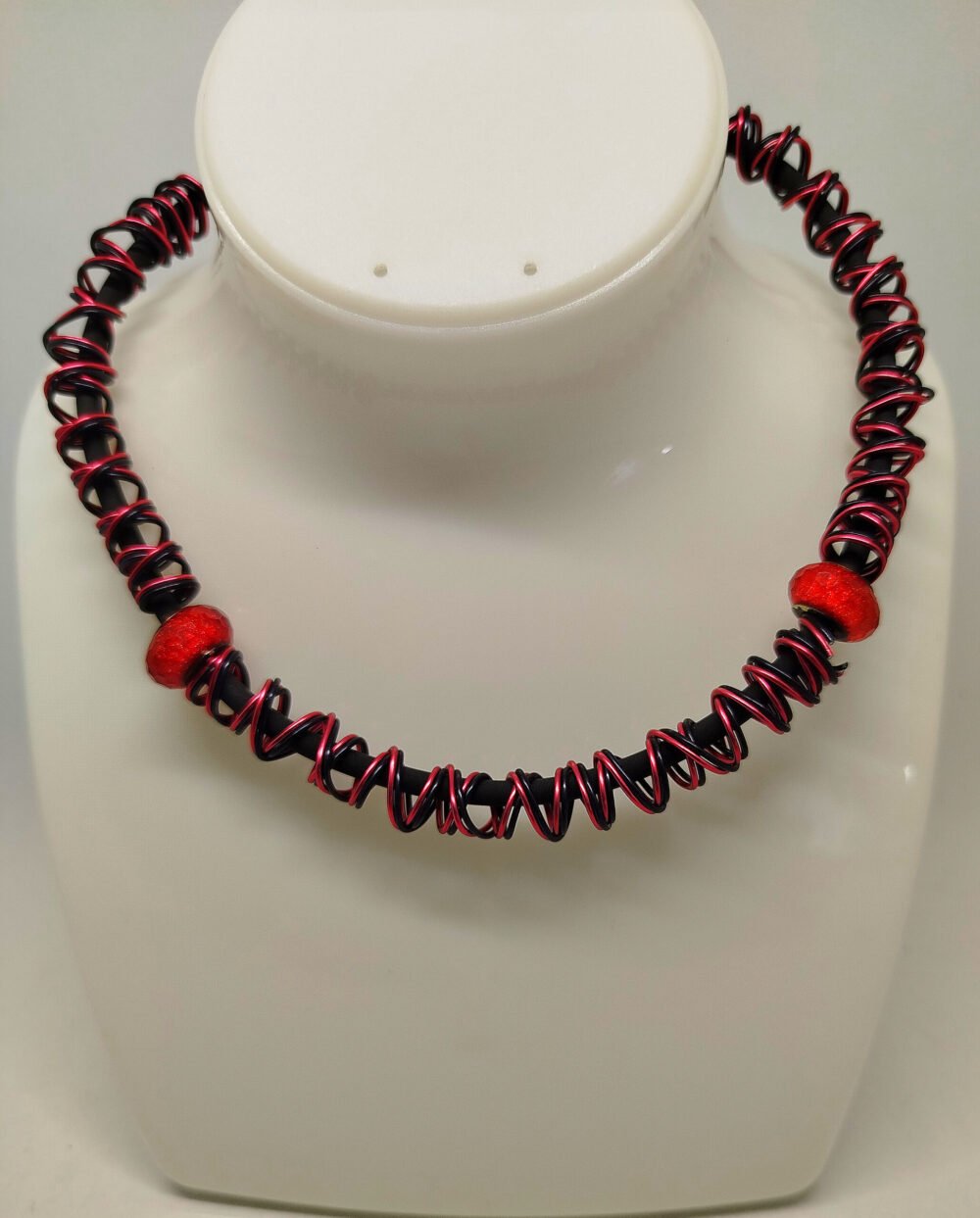 collier-femme-cree-en-fil-aluminium-rouge-et-noirs-en-forme-de-spirales-et-3-belles-perles-en-strass-fixees-sur-un-caoutchouc-noir-avec-fermoir-mousqueton