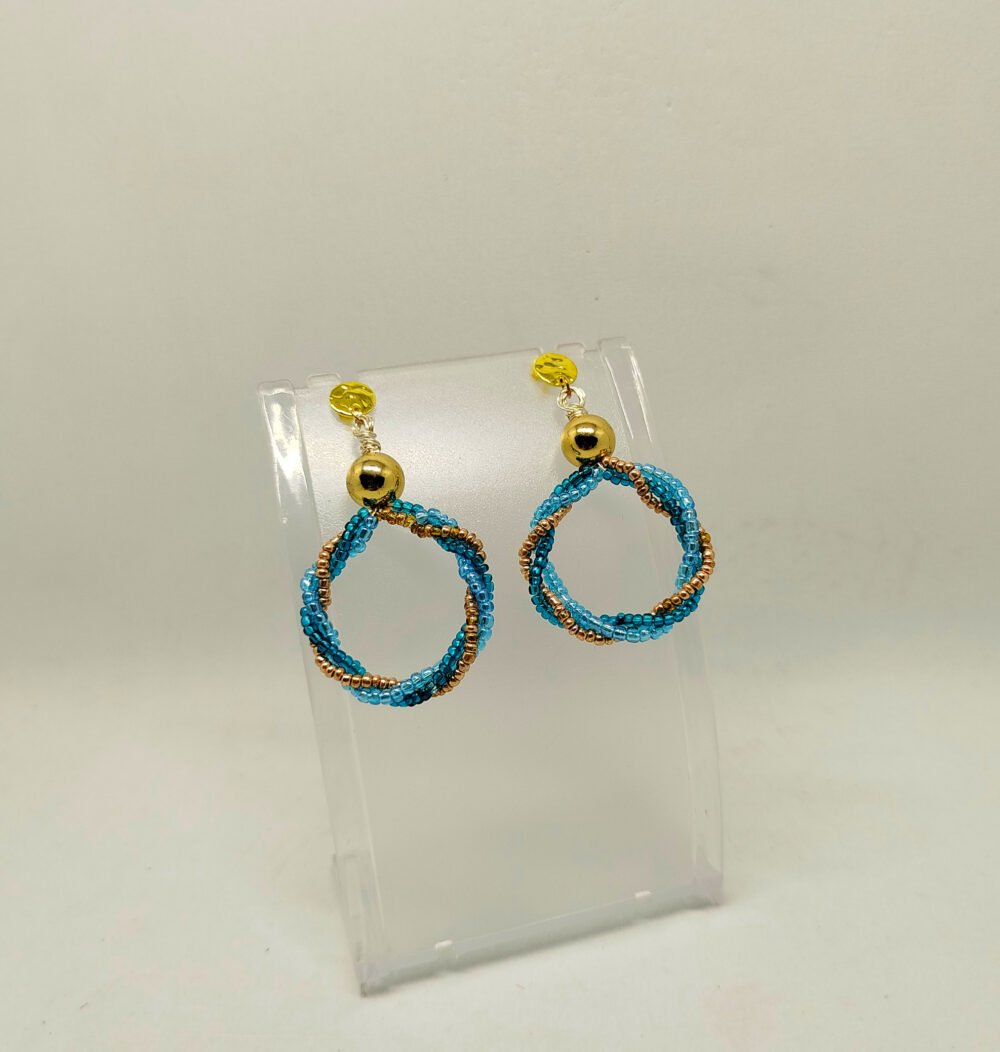 créoles soigneusement créées avec 3 rangées de petites perles fixées à des clous d'oreilles dorés en acier