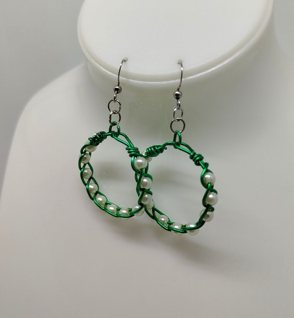 créoles tressées avec du fil aluminium vert et avec des perles couleur nacré fixées à des crochets hypoallergéniques