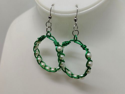 créoles tressées avec du fil aluminium vert et avec des perles couleur nacré fixées à des crochets hypoallergéniques