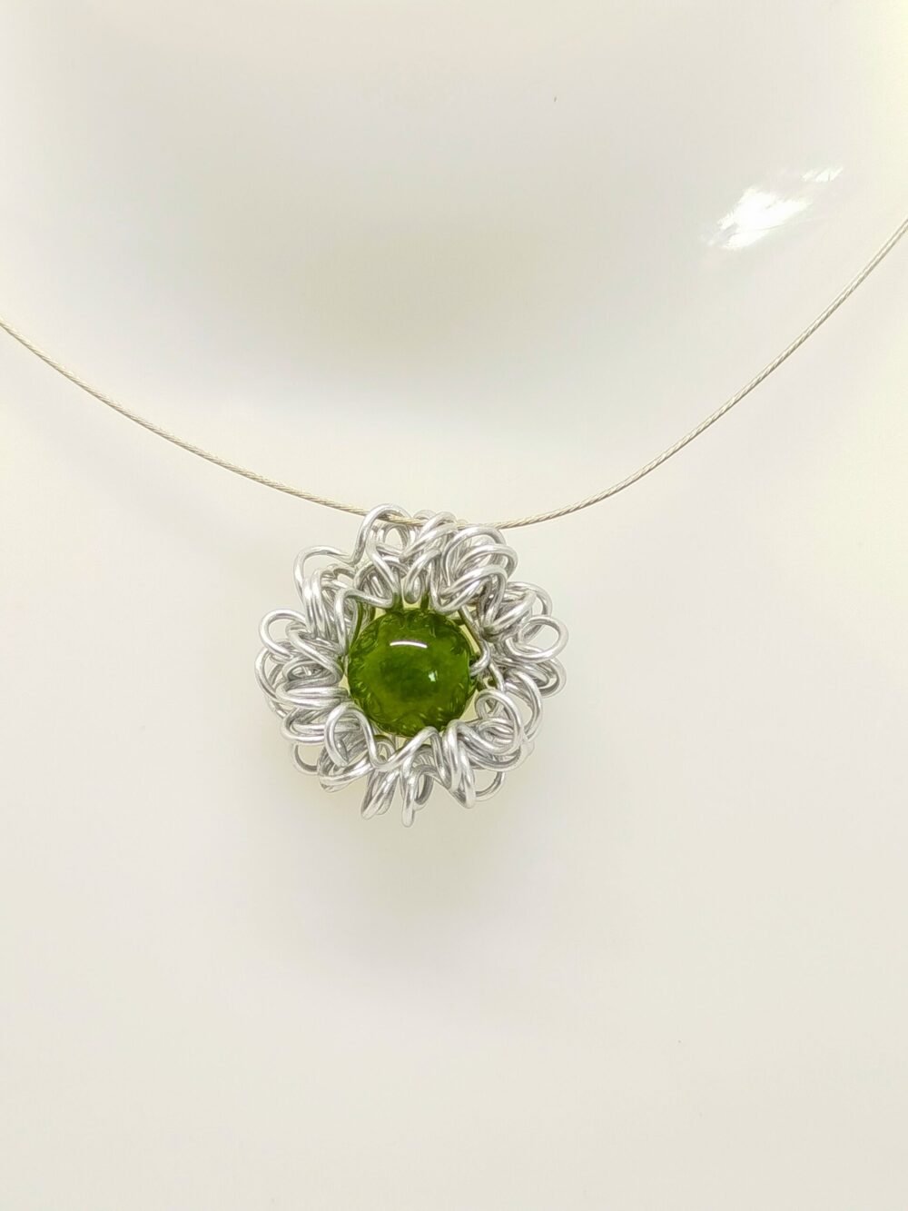 pendentif en fil d'aluminium qui entoure une belle pierre naturelle jade fixé sur câble à bijoux
