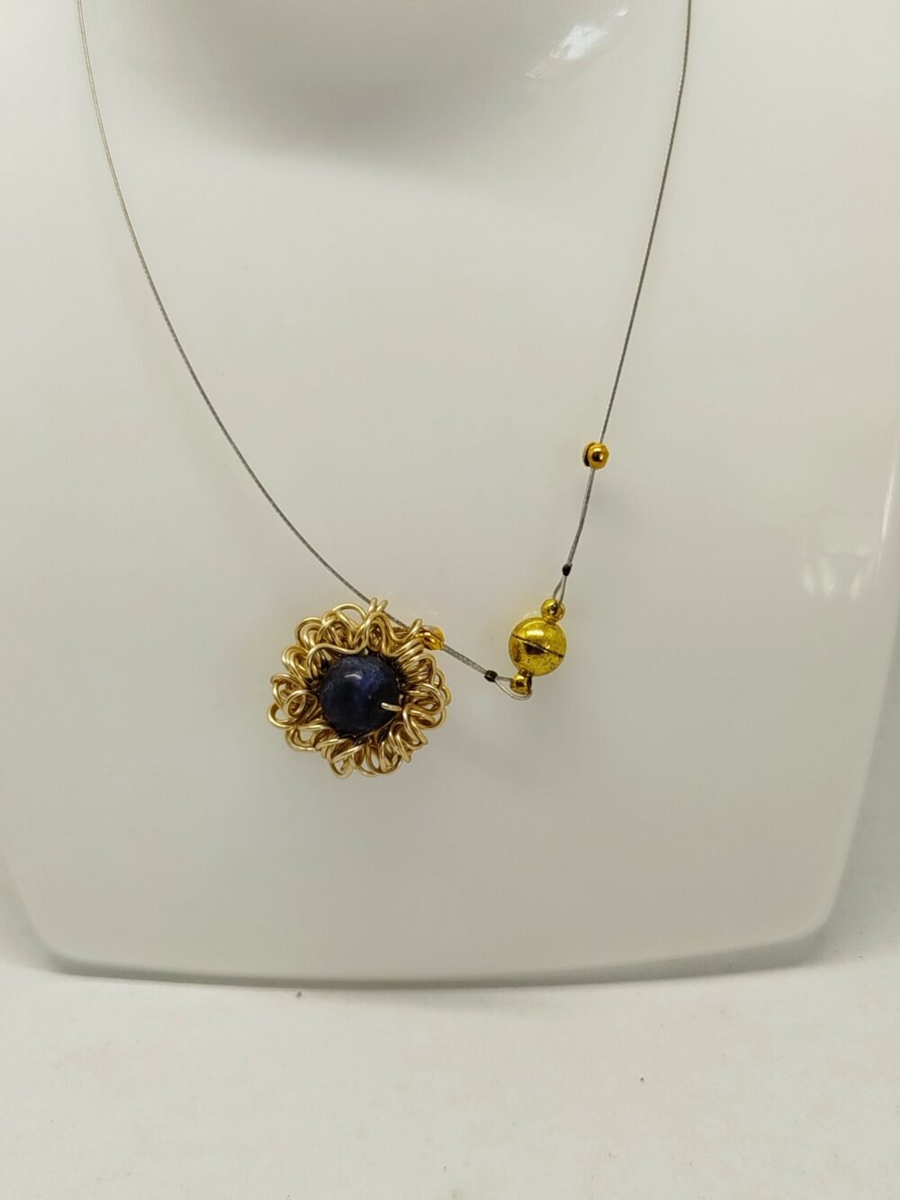 pendentif en fil d'aluminium doré qui entoure une belle pierre naturelle lapis lazuli fixé sur câble à bijoux fermoir aimanté