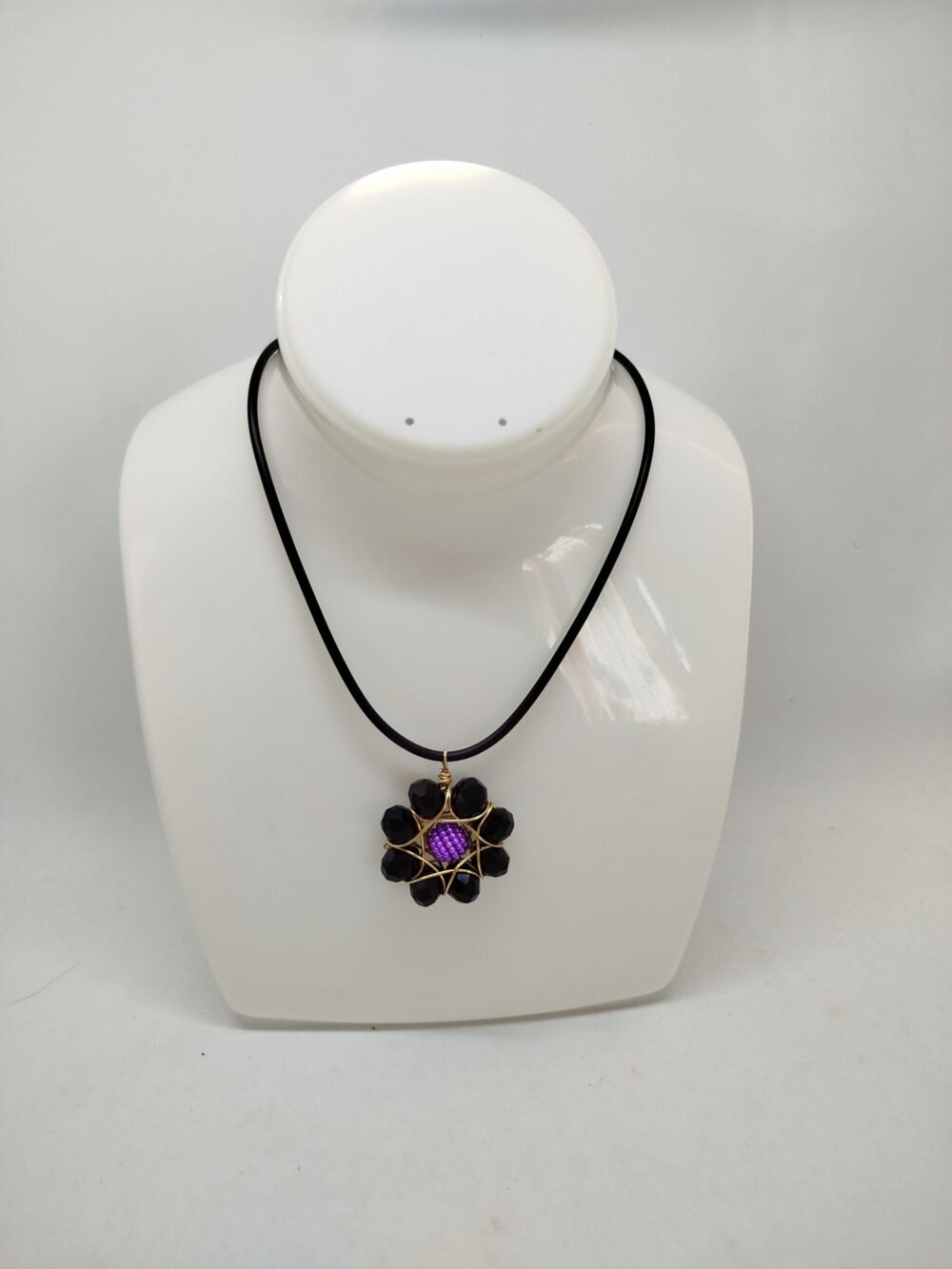 sautoir en perles à facettes noires entouré de fil aluminium doré en forme de fleur