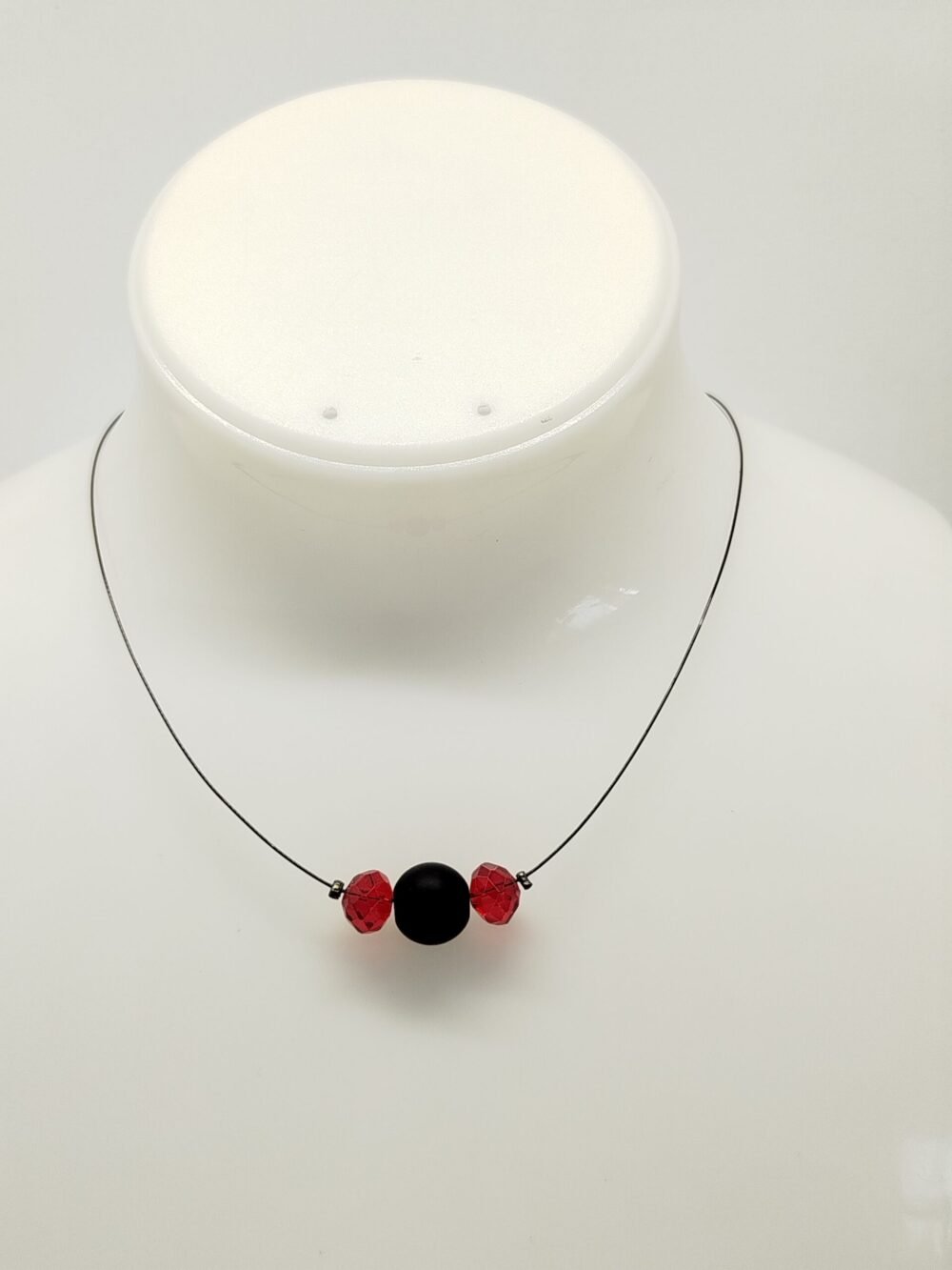 pierre onyx accompagné de perles rouge fixées sur câble à bijoux noires