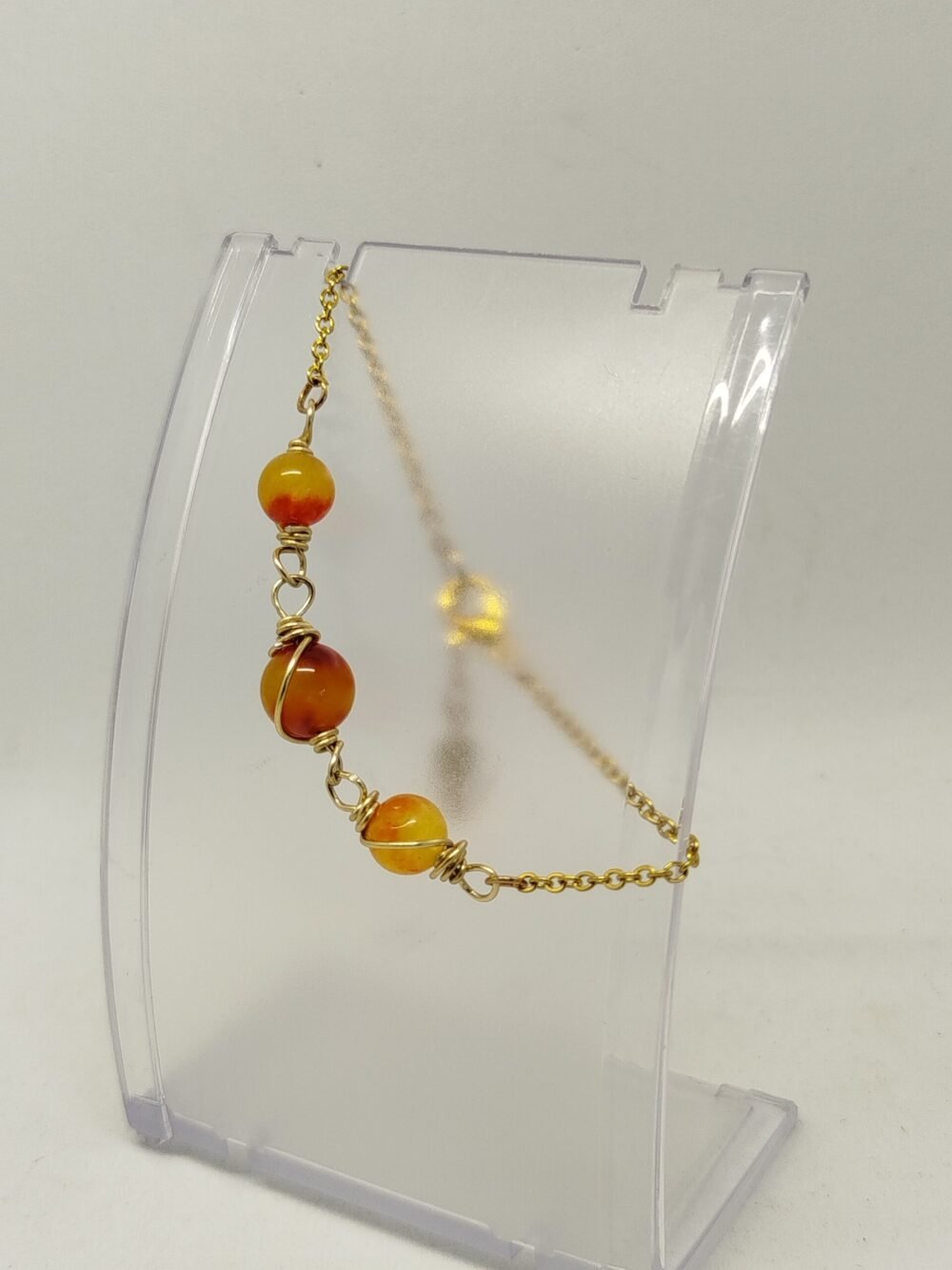 bracelet soigneusement créé avec des pierres naturelles Jaspe Orange qui sont entourées de fil aluminium couleur doré. La chaîne est en acier inoxydable couleur doré.