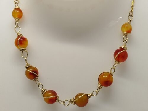 collier soigneusement créé avec des pierres naturelles Jaspe Orange qui sont entourées de fil aluminium couleur doré. La chaîne est en acier inoxydable couleur doré. collier soigneusement créé avec des pierres naturelles Jaspe Orange qui sont entourées de fil aluminium couleur doré. La chaîne est en acier inoxydable couleur doré.